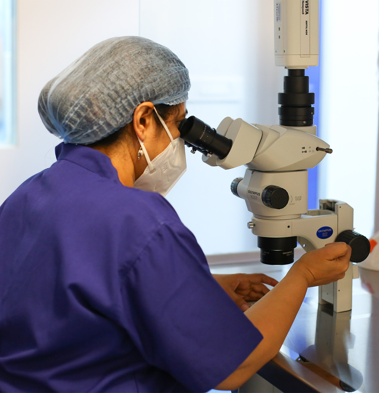 Embryologist working with advanced microscope in Nestlings fertility laboratory